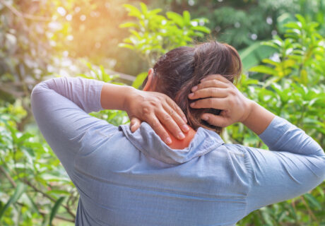 woman suffering from neck pain at outdoor