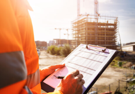 OSHA inspection worker at construction site inspecting proper rules and regulations procedures